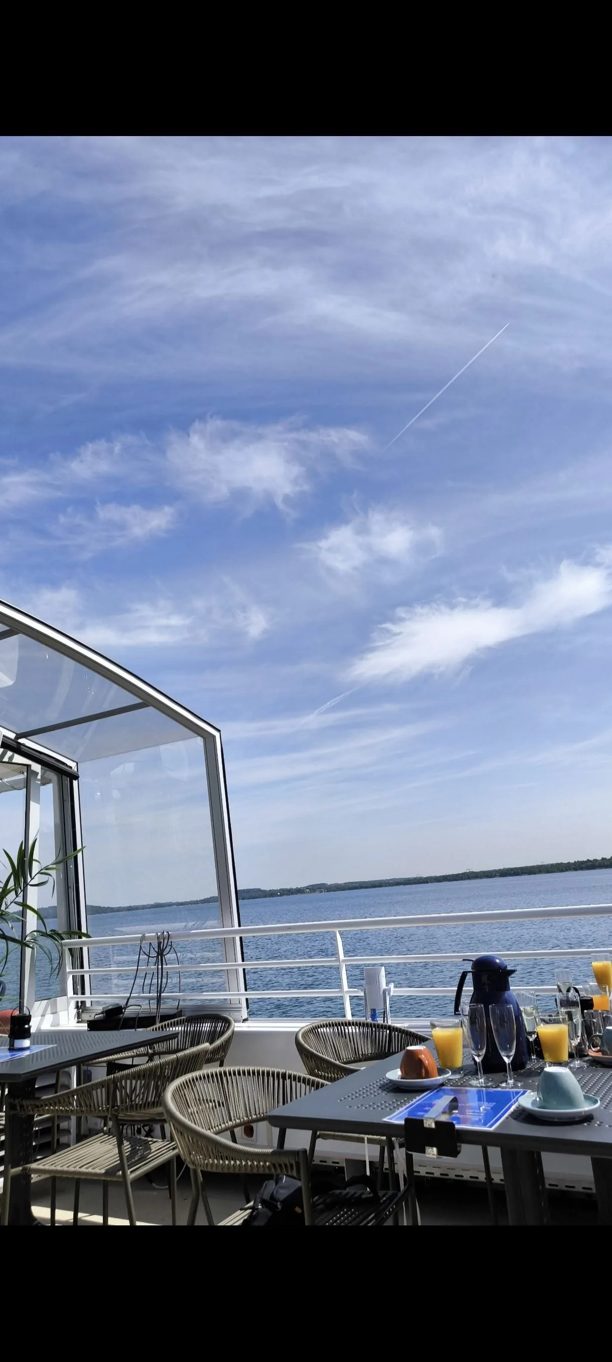 Offenes Oberdeck mit Tischen und Blick über den See